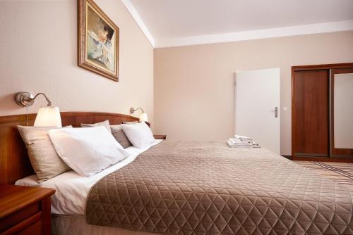 a bedroom with a large bed with white pillows at Hotel Anton by DNS in Pruszków