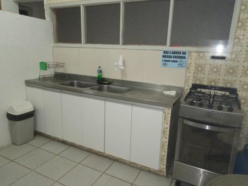 a kitchen with a sink and a stove at Casa Recife Pousada in Recife