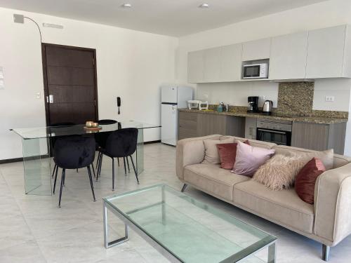 a living room with a couch and a glass table at Hermoso departamento con piscina y estacionamiento in Asuncion