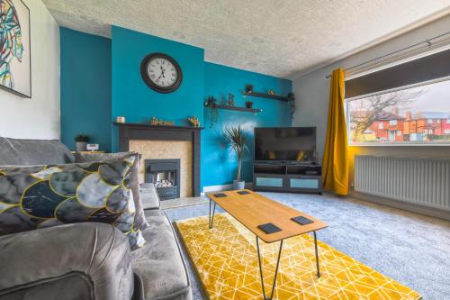 a living room with a couch and a table at Rookwood house - spacious home with free parking - Short Stay Leeds in Killingbeck