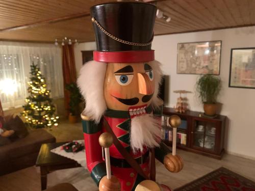 a nutcracker statue in a living room with a christmas tree at Ferienwohnung Zur Glewe in Neustadt-Glewe