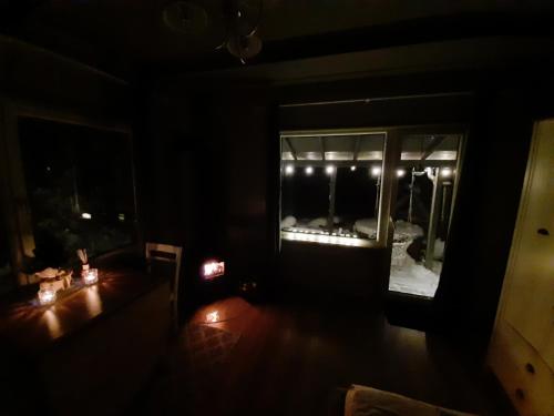 a dark living room with a table and a window at Gilė -'Virš Ąžuolų' - Forest SPA - Horses - Lake - Chalet in Paplatelė