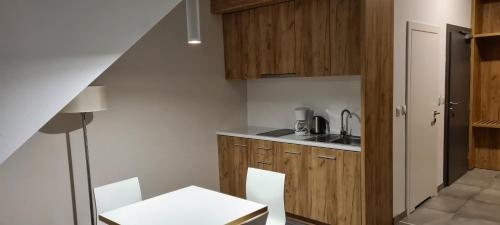 una cucina con mobili in legno, tavolo e sedie di Apartament Czarna Góra 419 a Sienna