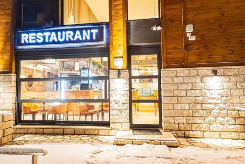 a restaurant with a sign on the side of a building at Modern Mountain - Apartment Najomi in Kolašin