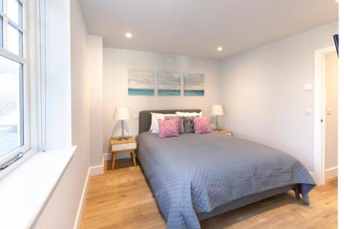 a bedroom with a bed with two lamps and a window at Hampden Apartments - The Anne in Windsor