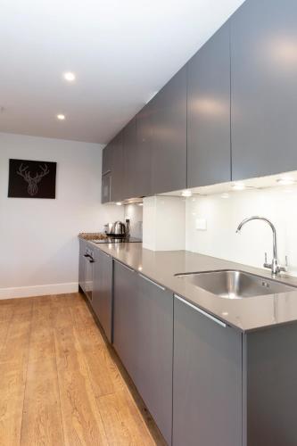 a kitchen with stainless steel cabinets and a sink at Hampden Apartments - The Anne in Windsor