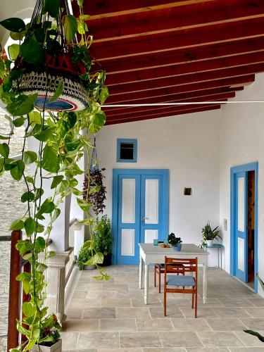 a dining room with a table and blue doors at 7Kamares in Pano Lefkara