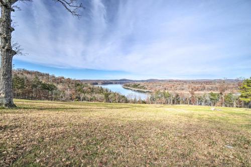 a field with a tree and a lake in the background at Table Rock Lake Home - Fire Pit and Lake Views! in Golden