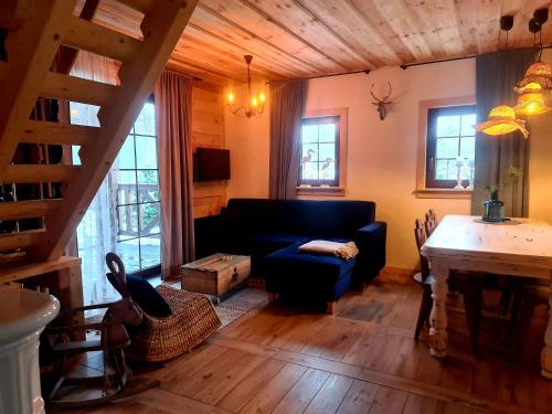 a living room with a blue couch and a table at Casa Del Campo 1 in Gaśno