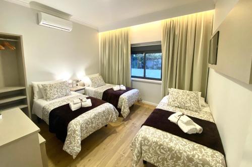 a hotel room with two beds and a window at Sol Rio De Alverca in Quinta da Verdelha