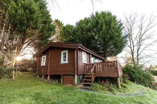 a small house sitting on top of a grass field at Rustic Log cabin in Snowdonia By Seren Short Stays in Trawsfynydd