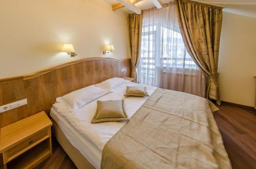 a bedroom with a bed with two pillows on it at Hata Hutsula in Mykulychyn