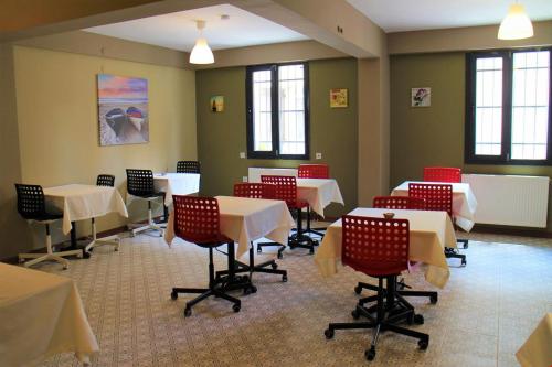 jadalnia ze stołami, krzesłami i oknami w obiekcie Moda Hotel w mieście Kırklareli