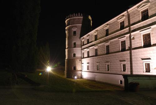 a castle at night with a light next to a building at Zamek w Krasiczynie in Krasiczyn