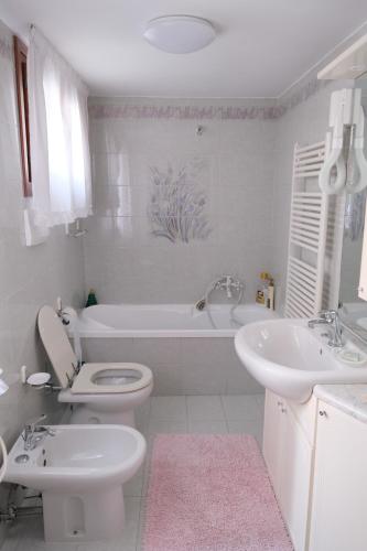 een badkamer met een toilet, een bad en een wastafel bij Casa degli Artisti in Burano