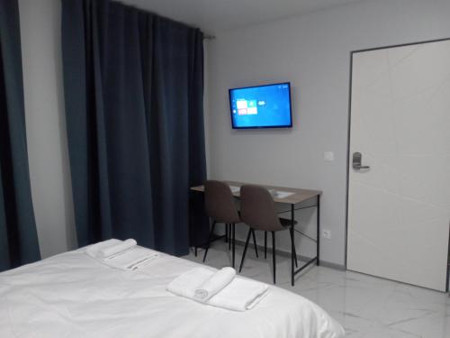 1 dormitorio con cama, mesa y TV en 39 Apart Hotel, en Leópolis