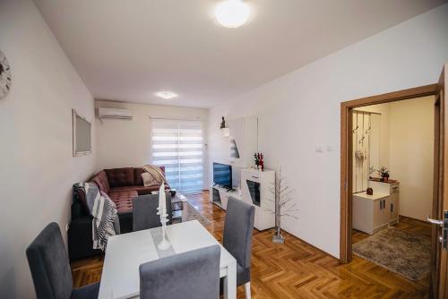 un soggiorno con un tavolo e un divano di Harmonija 3 a Trebinje