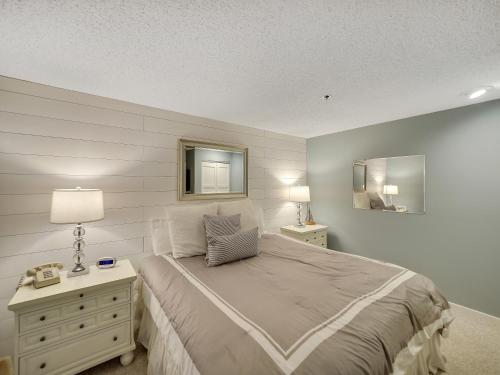 um quarto com uma cama e uma cómoda com um candeeiro em 232 Edgewater Inn em Charlevoix