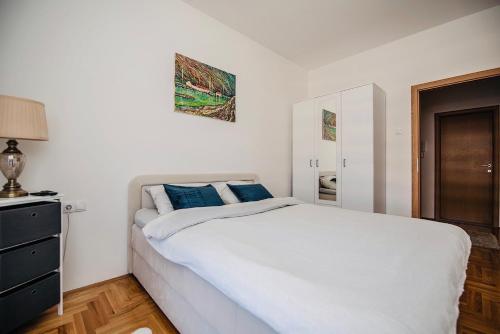 una camera da letto con un grande letto bianco con cuscini blu di Harmonija 3 a Trebinje