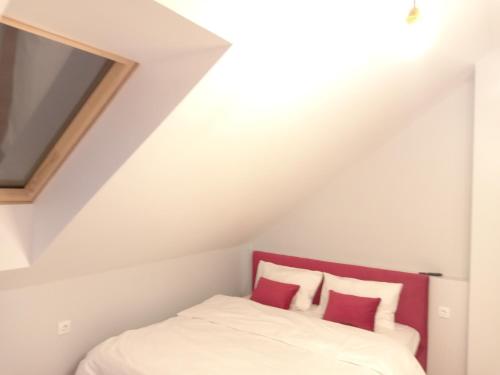 a bedroom with a bed with red and white pillows at 39 Apart Hotel in Lviv