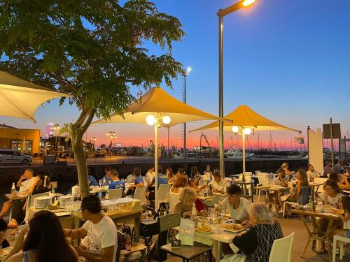 a group of people sitting at tables in a restaurant at Holiday Thea & Residence in Gabicce Mare