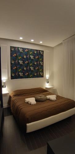 a bedroom with a large bed with a painting on the wall at B&B Diamond in Reggio Calabria