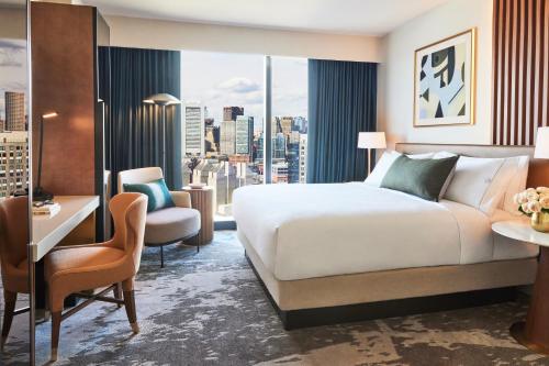 um quarto de hotel com uma cama, uma secretária e uma janela em Omni Boston Hotel at the Seaport em Boston