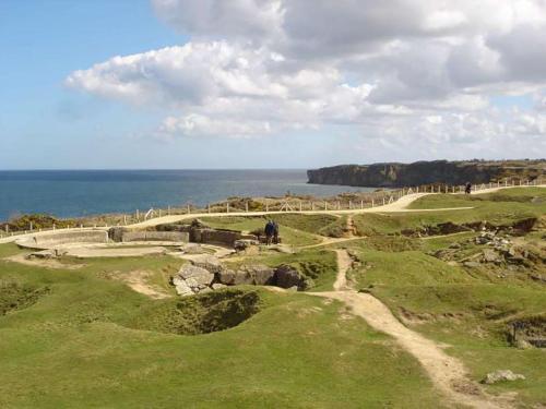 a view of a golf course with the ocean in the background at Normand'Histoire Gite 1869 in Isigny-sur-Mer