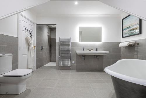 a bathroom with a sink, toilet and bathtub at Skeabost House Hotel in Portree