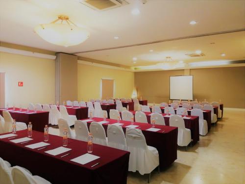 a conference room with tables and chairs and a screen at Holiday Inn Hotel & Suites Centro Historico by IHG in Guadalajara