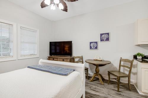 a bedroom with a bed and a table and a tv at Village of South Walton CB 243 in Rosemary Beach