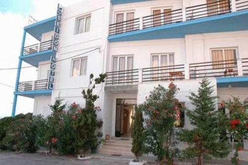a white building with trees in front of it at Poseidon Hotel in Heraklio Town
