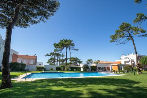 a swimming pool in a yard with trees and buildings at Casa do Suave Mar in Esposende