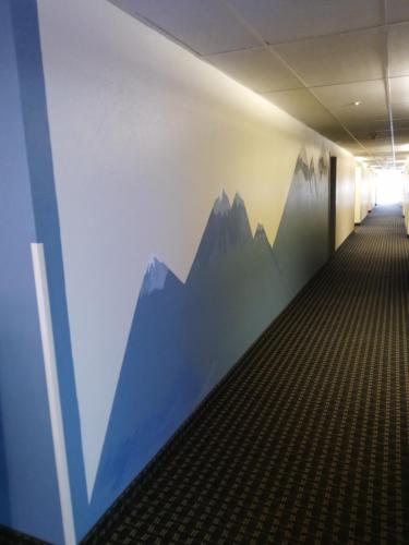 a hallway with a mural of mountains on the wall at Super 8 by Wyndham Windsor in Windsor