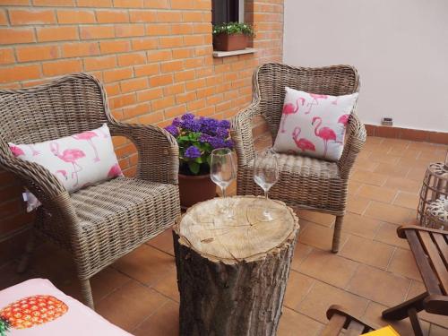 twee stoelen en een tafel met wijnglazen op een patio bij Blanco Y Negro in Zamora