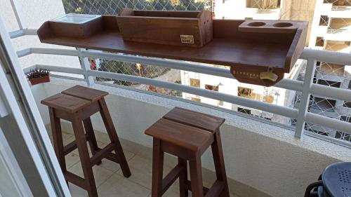 a table and two stools on a balcony with a suitcase at Departamento Nuevo en Condominio Viña del Mar in Viña del Mar