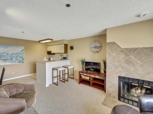 a living room with a fireplace and a kitchen at 236 Edgewater Inn in Charlevoix