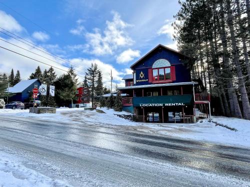 a building on the side of a snow covered street at Complexe LIVTremblant by Gestion ELITE - LIV3 in Mont-Tremblant
