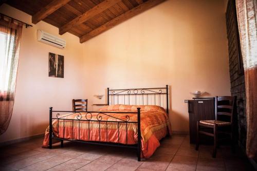 フルミニマッジョーレにあるAgriturismo Il Gineproのベッドルーム1室(ベッド1台、椅子2脚付)