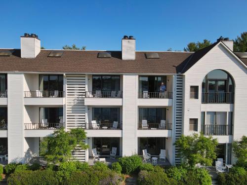 a large apartment building with a man standing on the balcony at 238 Edgewater Inn in Charlevoix