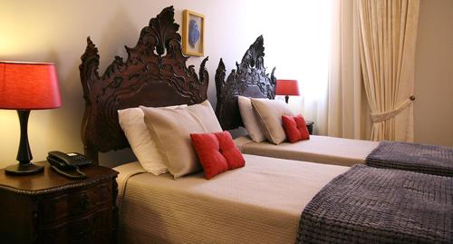 1 Schlafzimmer mit 2 Betten und roten Kissen in der Unterkunft Casa Manuel Espregueira e Oliveira in Viana do Castelo