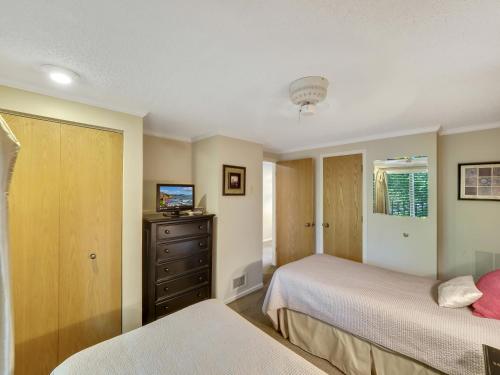 a bedroom with two beds and a dresser at 343 Edgewater Inn in Charlevoix