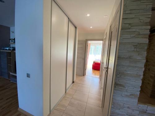 a hallway leading to a living room with a stone wall at Tomas Apartment in Cēsis