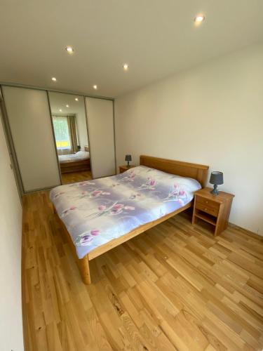a bedroom with a bed and a wooden floor at Tomas Apartment in Cēsis