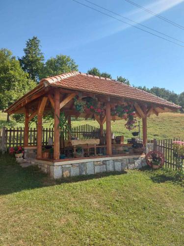 einem hölzernen Pavillon mit einer Bank auf einem Feld in der Unterkunft Domaćinstvo Sindžirević in Nova Varoš