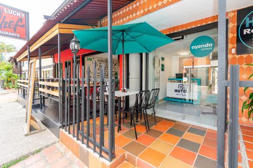a table with chairs and an umbrella outside of a store at Ayenda Casa San Pablo in Medellín