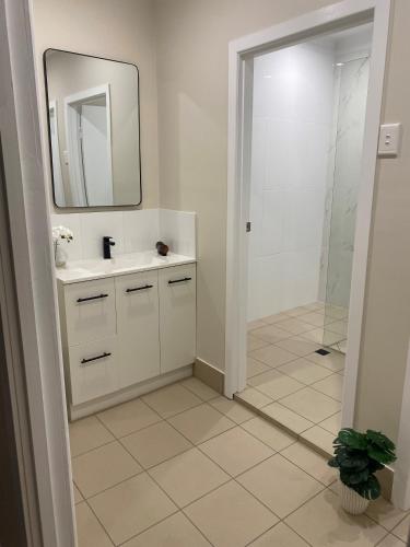 a white bathroom with a sink and a mirror at Peddlars Rest in Toogoolawah