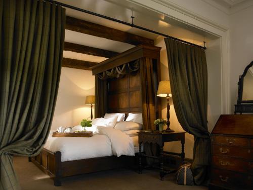 a bedroom with a canopy bed with white pillows at Trump International Golf Links & Hotel Doonbeg Ireland in Doonbeg