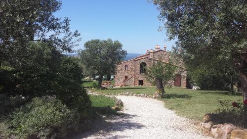 an old stone house with a path leading to it at Azienda Agrituristica Le Chiuse in Manciano