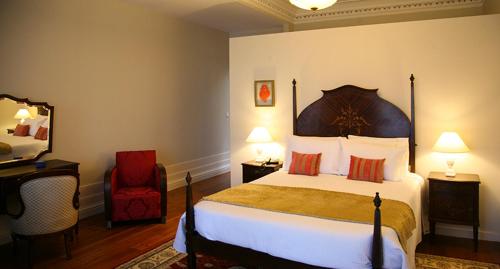 a hotel room with a bed and a red chair at Casa Manuel Espregueira e Oliveira in Viana do Castelo